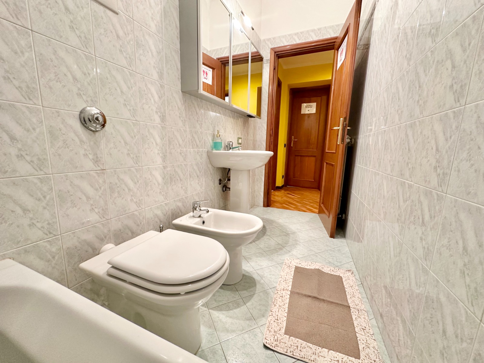 Bagno moderno con  vasca doccia spaziosa, piastrelle eleganti e amenities di qualità