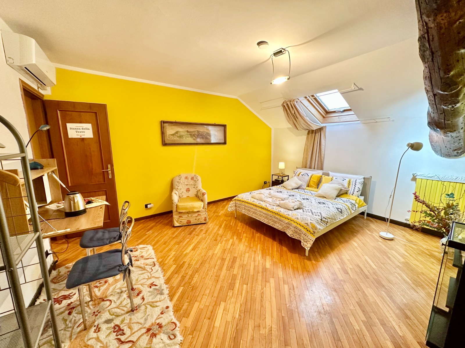 Rustic Italian bedroom featuring exposed wooden beam ceiling and traditional stone walls